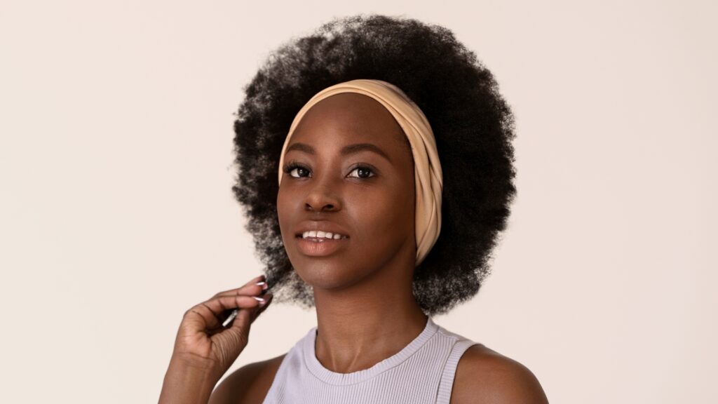 Smiley woman with afro hair posing side view